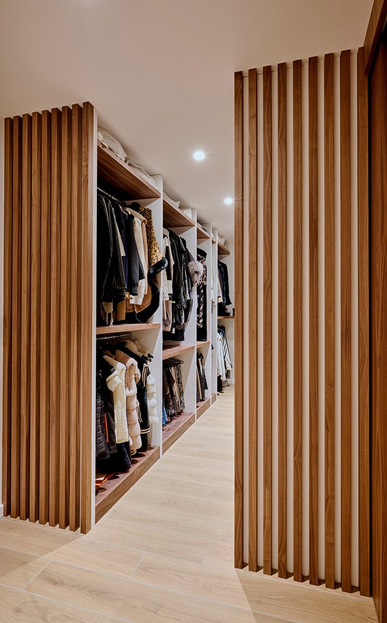 Dressing sur-mesure ouvert, portes à lames verticales en bois noyer, aménagement intérieur luxe HAERT Lille.