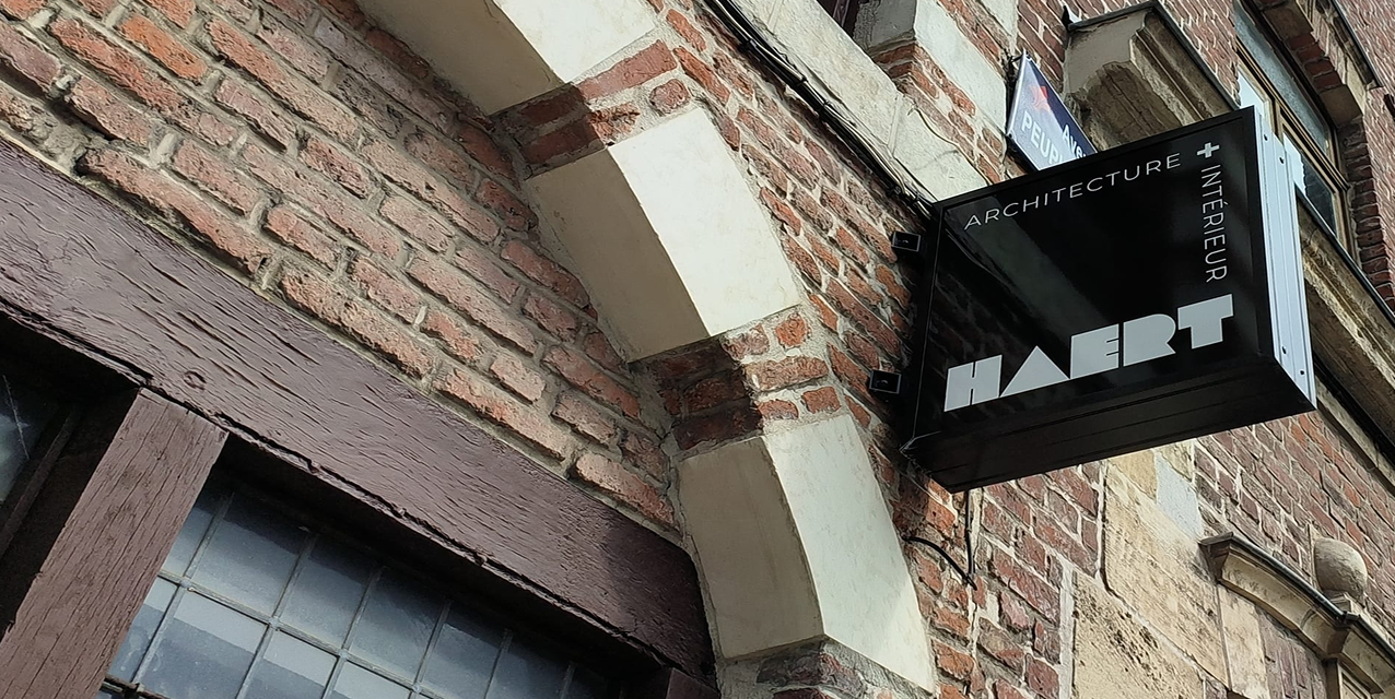 Photo de la façade des bureaux HAERT à Lille avec les alcôves et les briques ainsi que l'enseigne 